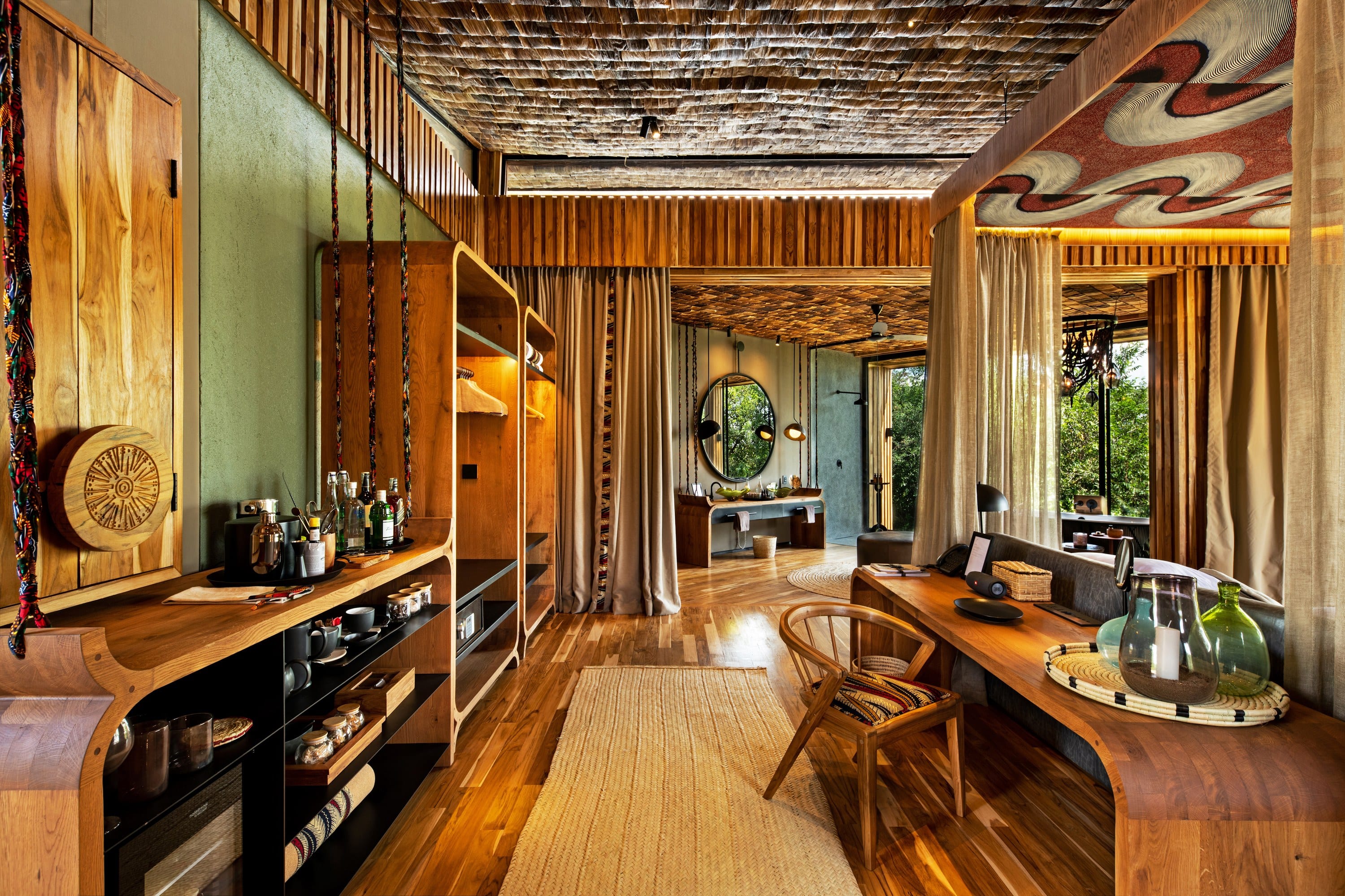 A suite sitting room with a pair of leather and timber chairs and a small writing table.