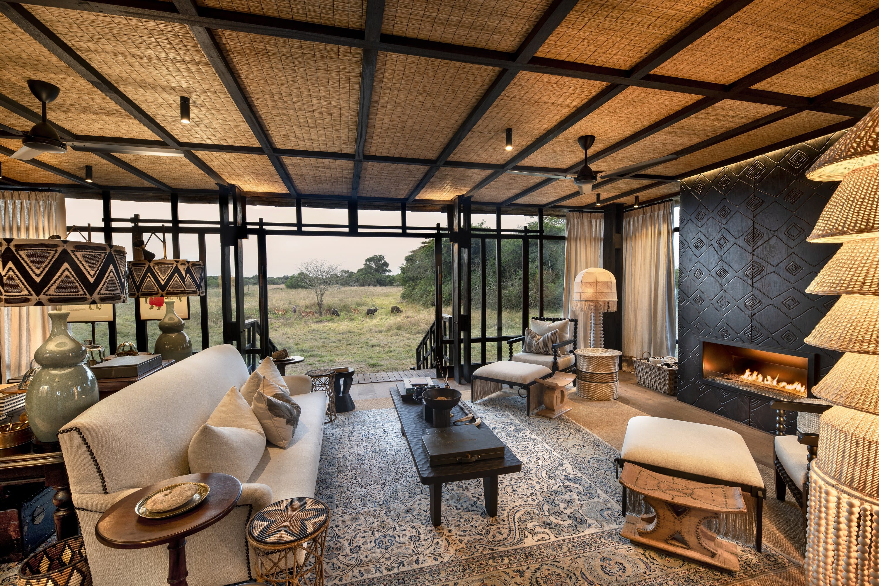 A lodge library with a tree trunk, low timber seating, bookshelves, and a chevron timber floor.