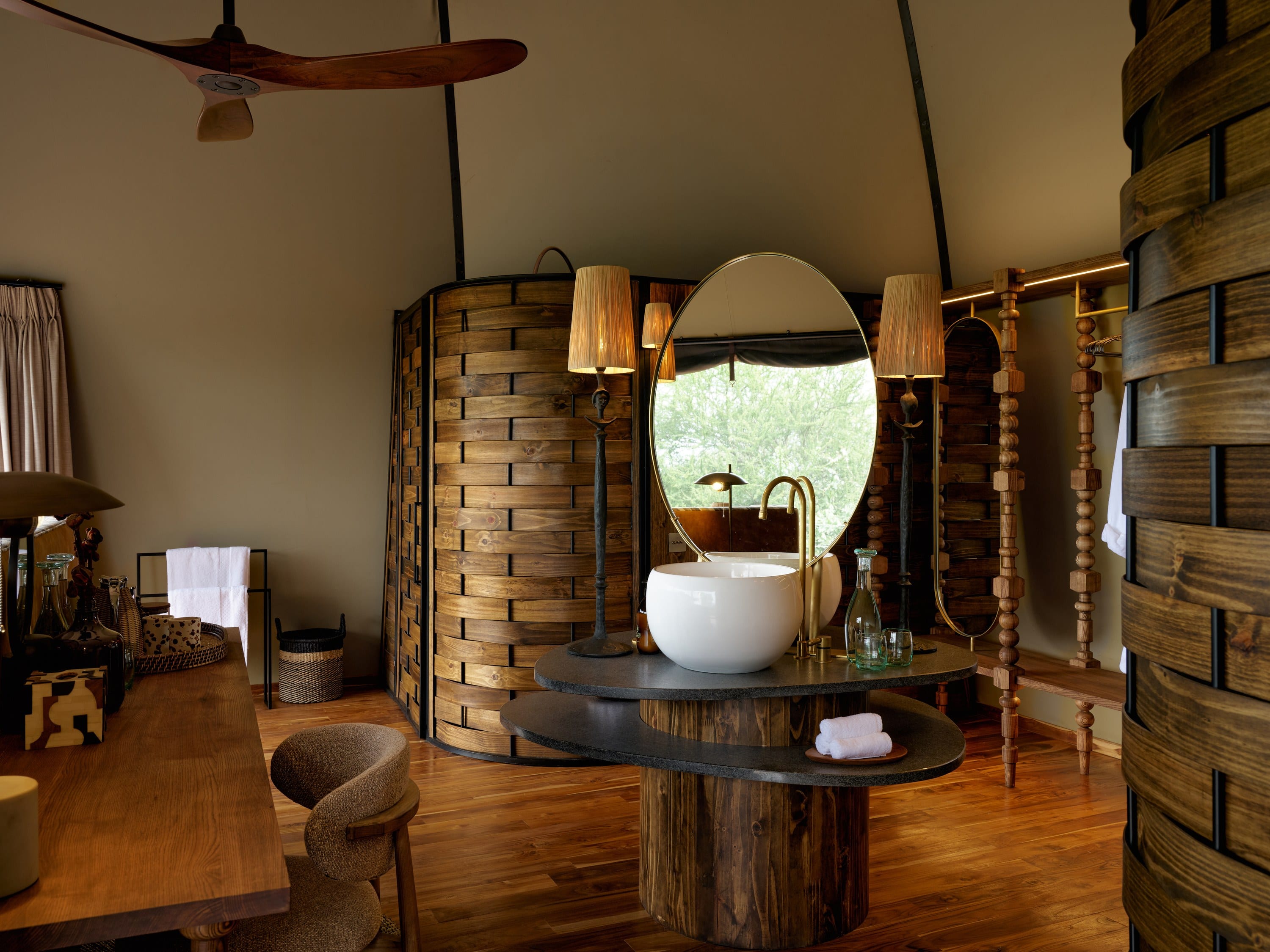A timber deck and pool under a thatched roof, opening onto the savanna.